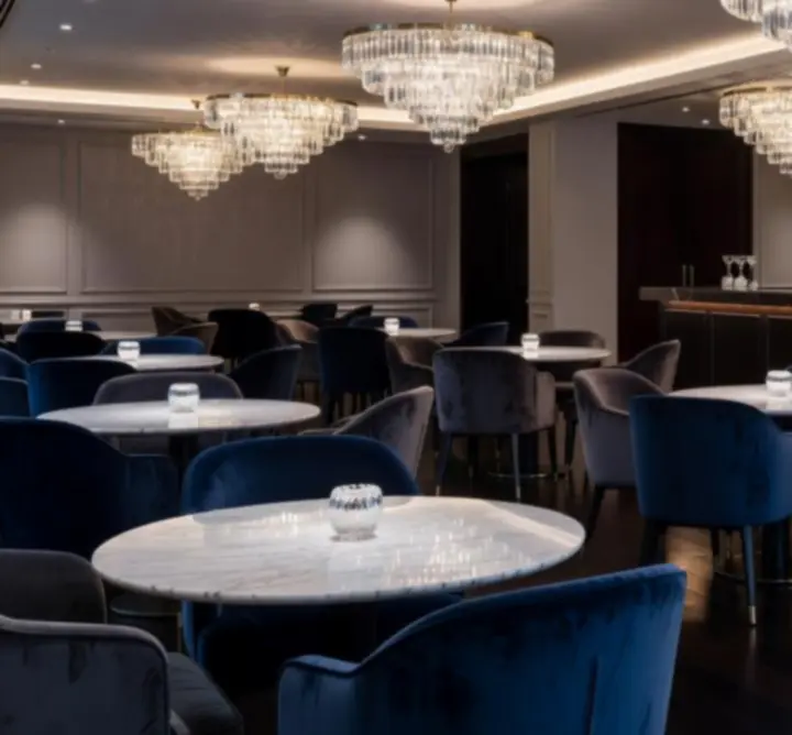 Kristálycsillárok, márvány asztalok és bársony székek egy modern lounge enteriőrben